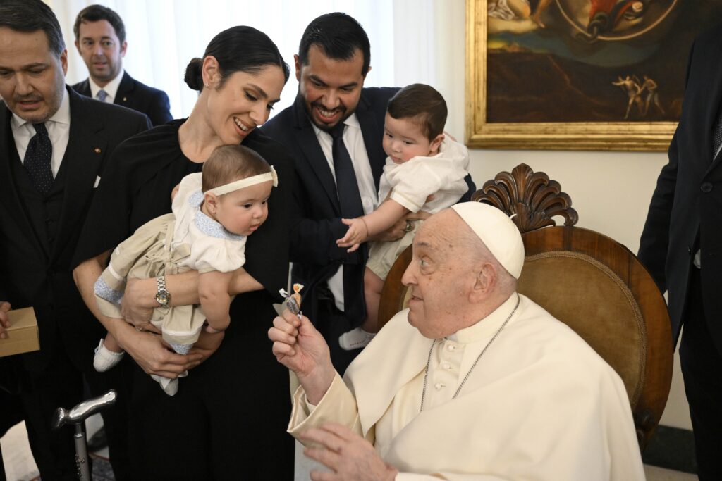 Pope Francis hands candy to a child at the end of a meeting with members of the Spanish "Gaudium et Spes" Foundation at his residence, the Domus Sanctae Marthae, before checking into Rome's Gemelli hospital February 14, 2025, for tests and treatment of bronchitis.