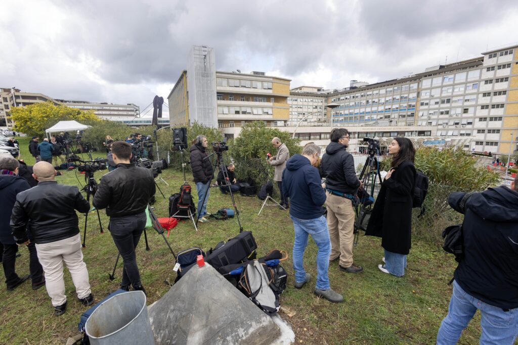 Reporters, television crews and photographers gather on a hillside at Rome's Gemelli hospital February 14, 2025, after Pope Francis was admitted for tests and treatment of bronchitis.