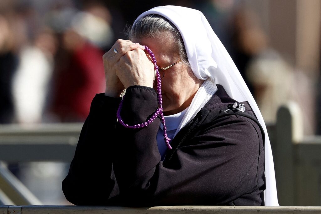 A nun prays at St. Peter's Square February 16, 2025, while Pope Francis is hospitalized in Rome's Gemelli hospital for bronchitis treatment.