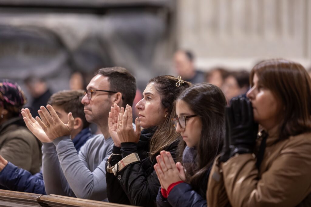 People pray for the ailing Pope Francis during a special evening Mass on February 23, 2025, in Rome's Basilica of St. John Lateran.