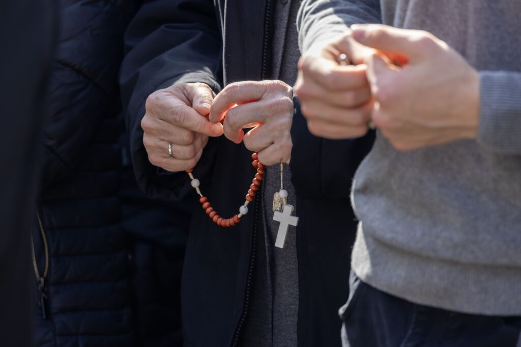 People pray the rosary in the courtyard outside Rome's Gemelli hospital February 23, 2025, where Pope Francis is being treated for double pneumonia.