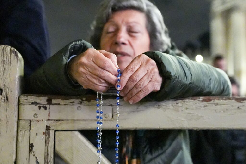 A woman holds a rosary as people join Cardinal Luis Antonio Tagle, pro-prefect of the Dicastery for Evangelization, in the recitation of the rosary for Pope Francis in St. Peter’s Square at the Vatican February 25, 2025.