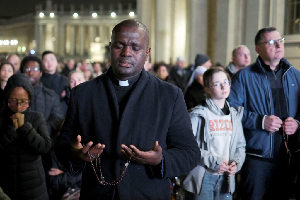 A priest prays as he attends a prayer service in St. Peter's Square at the Vatican late February 26, 2025, as Pope Francis continues his hospitalization. (OSV News photo/Guglielmo Mangiapane, Reuters)