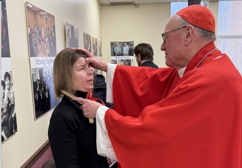 Cardinal Timothy Dolan blesses the throat of a staff member at the Meadowview at Wartburg assisted living facility in Mount Vernon on the Feast of St. Blaise, February 3, 2025.