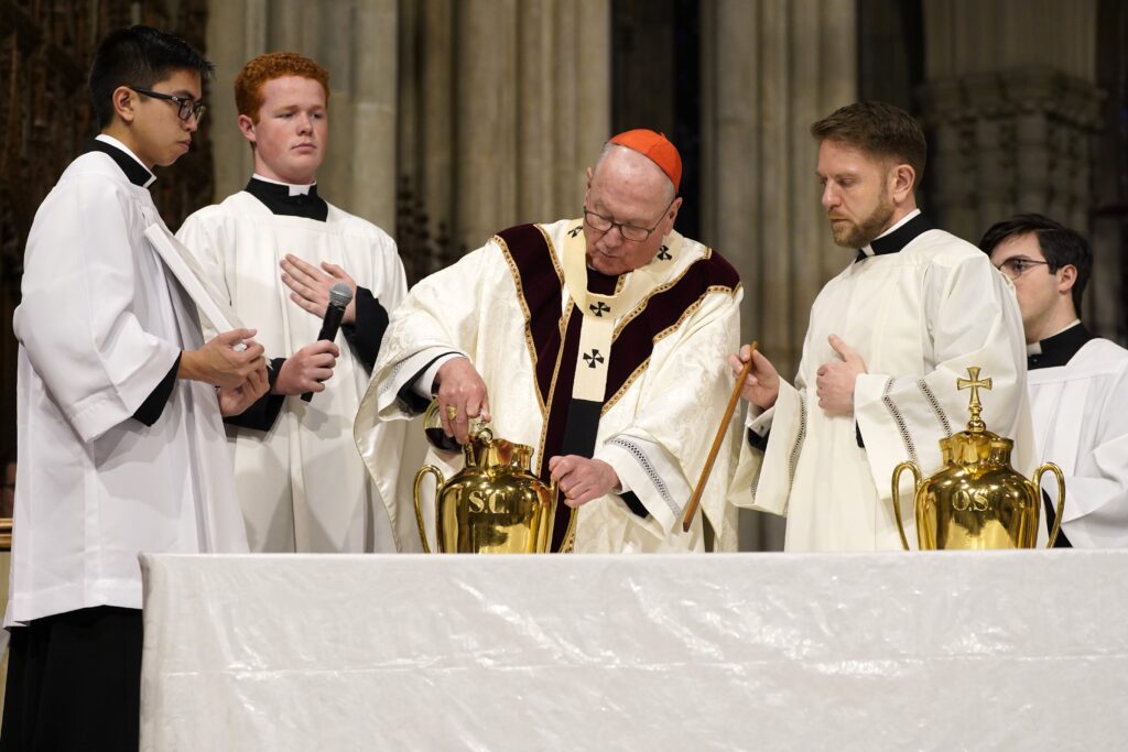 New York Cardinal Timothy M. Dolan pours fragrant balsam into a vessel of olive oil as he prepares to consecrate the chrism during the Archdiocese of New York's chrism Mass at St. Patrick's Cathedral in New York City March 26, 2024.