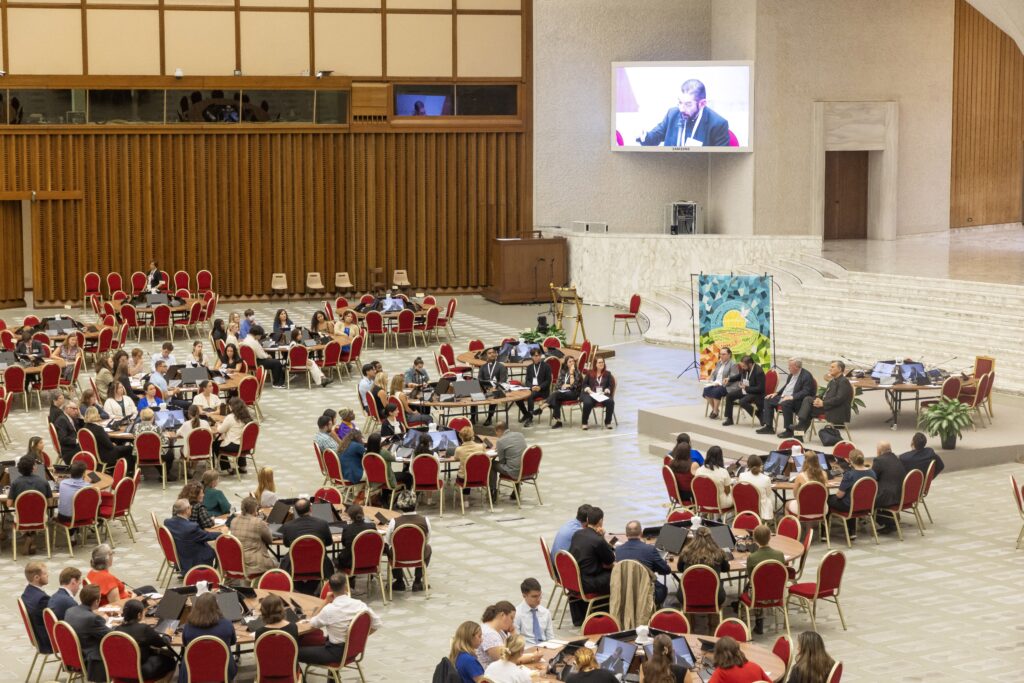 Bishop Daniel E. Flores of Brownsville, Texas, seated on stage and seen on a large screen, responds to questions from U.S. university students about the Synod of Bishops in the Paul VI Audience Hall at the Vatican October 18, 2024.