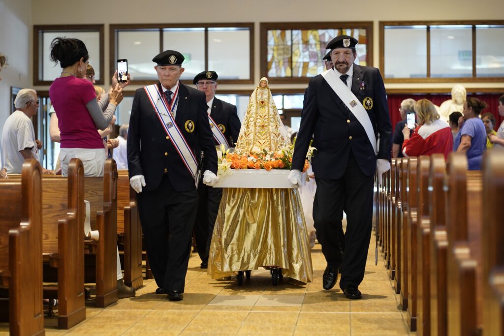 A Knights of Columbus honor guard representing the Commander John J. Shea Assembly of Eastern Suffolk County, processes with a statue of Mary at the beginning of a May crowning ceremony at St. Patrick Church in Smithtown on May 24, 2024.