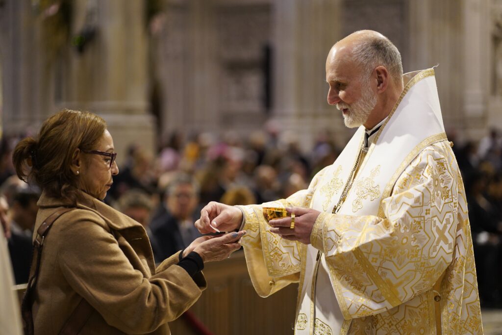 Metropolitan Archbishop Borys Gudziak of the Ukrainian Catholic Archeparchy of Philadelphia, distributes Communion during a memorial Mass for Pope Francis at St. Patrick's Cathedral in New York City on April 22, 2025.