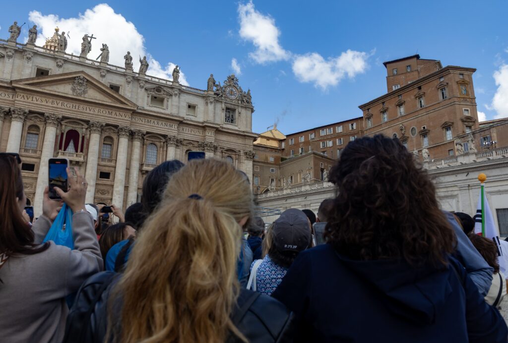 La gente observa cómo sale humo negro de la chimenea de la Capilla Sixtina el 8 de mayo de 2025, en el segundo día del cónclave en el Vaticano.