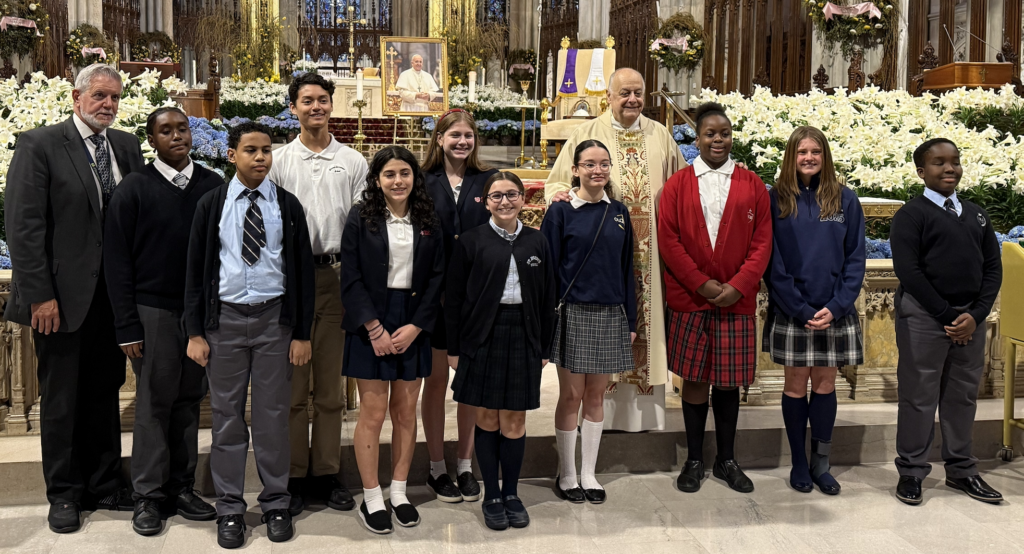 Monsignor Joseph P. LaMorte (center, in gold vestments), vicar general of the Archdiocese of New York, poses with Anthony Biscione (left), regional superintendent of Manhattan Schools in the Archdiocese of New York, and students from Manhattan Catholic elementary schools at the Archdiocesan Schools Memorial Mass for Pope Francis, May 2, 2025.