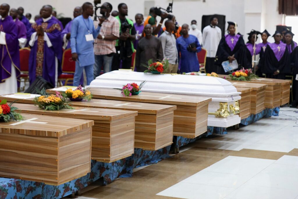 Flowers lie on caskets during a funeral Mass in the parish hall of St. Francis Xavier Church in Owo, Nigeria, June 17, 2022, for some of the 40 victims killed in a June 5 attack by gunmen during Mass at the church. Rep. Chris Smith, R-N.J., chairman of the House Foreign Affairs Subcommittee on Africa, urged the Trump administration on March 12, 2025, to designate Nigeria as a "country of particular concern" in response to violence in that country perpetrated against predominantly Christian communities.