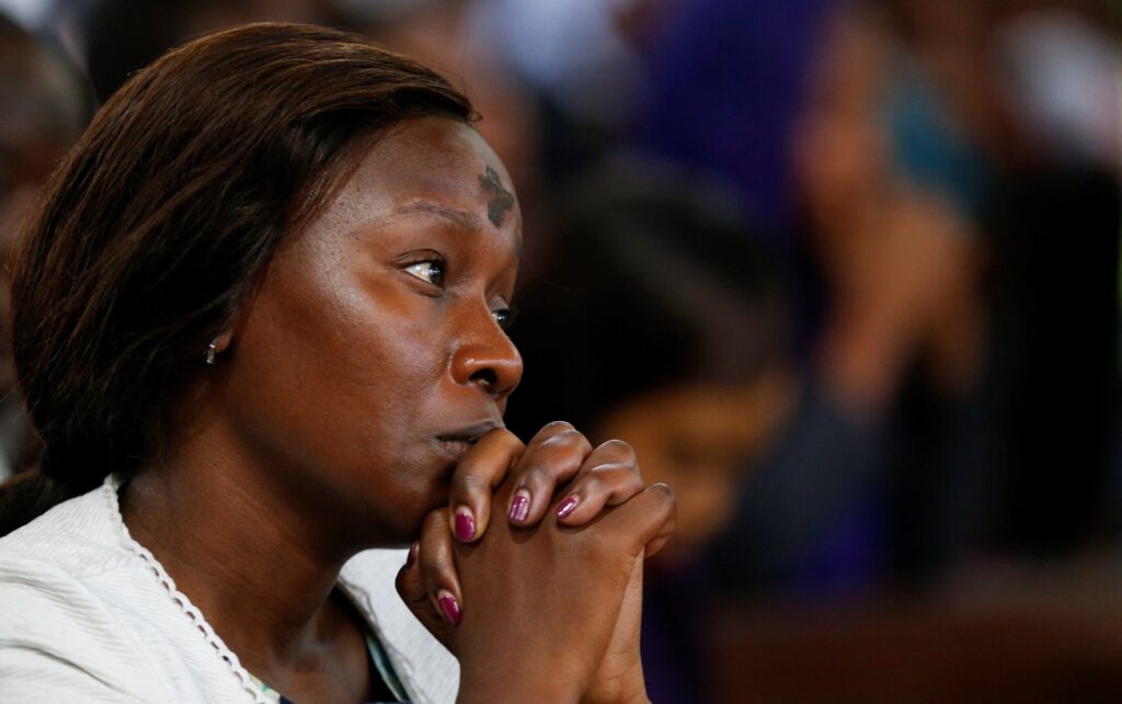 A woman marked with a cross on her forehead prays during Ash Wednesday Mass at the Cathedral Basilica of the Holy Family in Nairobi, Kenya.