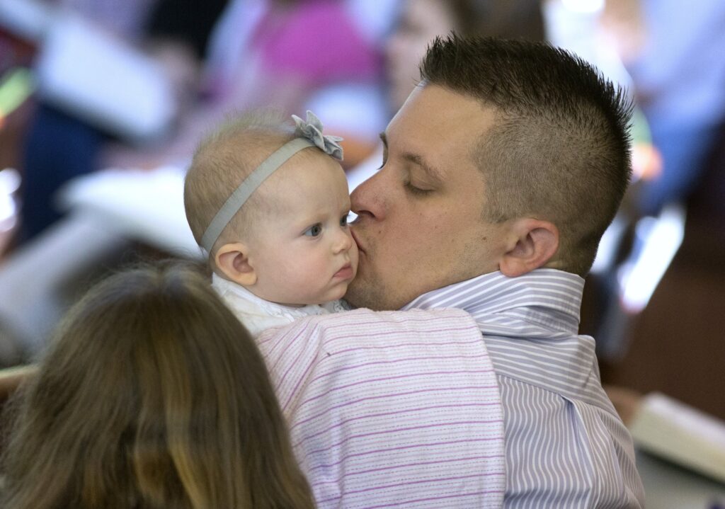 Una foto de archivo muestra a un hombre besando a su hija durante la Misa en la Iglesia de Jesús el Verbo Divino en Huntingtown, Maryland.