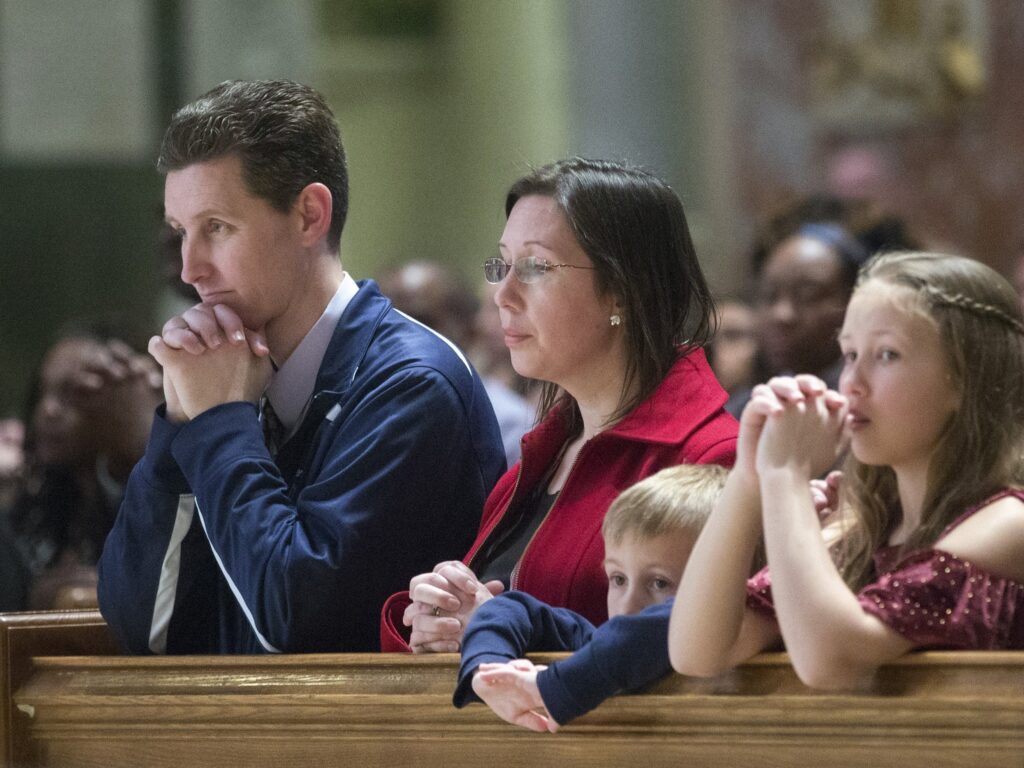 A file photo shows a family praying during Mass at the Cathedral of St. Matthew the Apostle in Washington. The Pew Research Center released an analysis on June 16, 2025, of U.S. Catholic life.