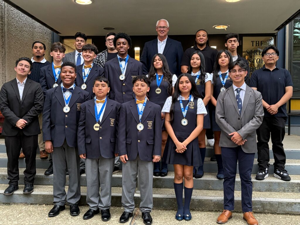 The San Miguel Academy Class of 2025 with their graduation medals. They are flanked by SMA alumni and Father Mark Connell, Executive Director. Image courtesy of San Miguel Academy.