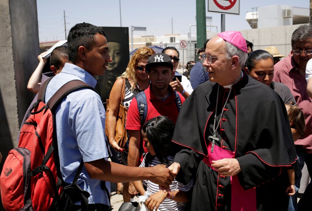 Bishop Mark J. Seitz of El Paso, Texas, and chair of the U.S. bishops' Committee on Migration, greets a Salvadoran migrant in Ciudad Juarez, Mexico, on June 27, 2019, who was deported after crossing the Paso del Norte international border from El Paso.