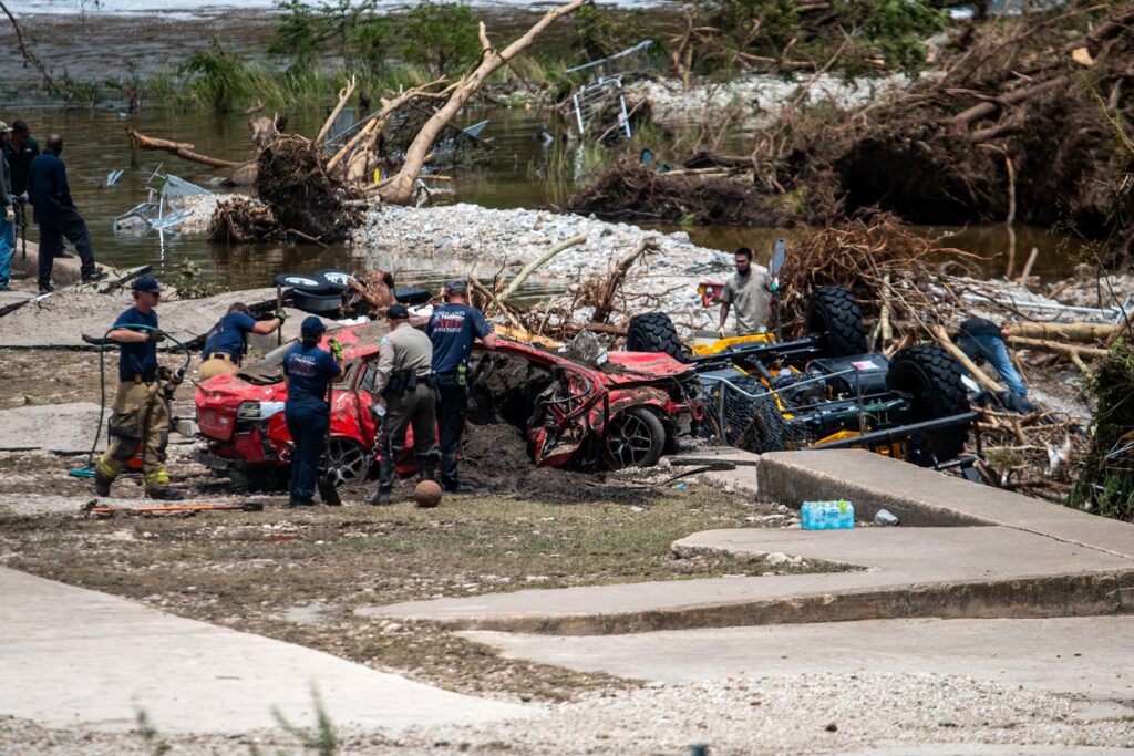 First responders attend to a vehicle pulled from the water in the aftermath of deadly flooding in Kerrville, Texas, on July 6, 2025.