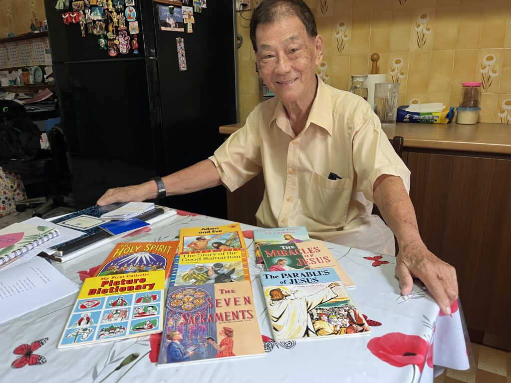 Andrew Goh, an 88-year-old catechist, poses for a photo at his home in Singapore July 2, 2025. Goh uses children's books to teach the Catholic catechism to the elderly who want to join the church.