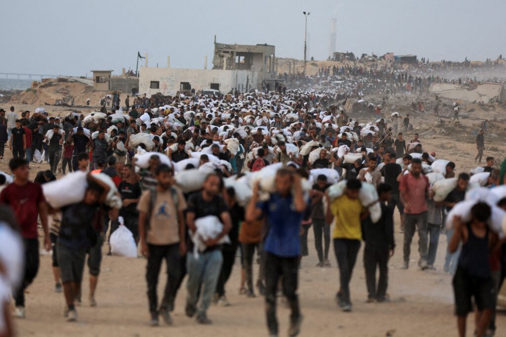 Palestinians carry aid supplies, that entered Gaza on trucks through Israel, in Beit Lahia, in the northern Gaza Strip July 29, 2025.