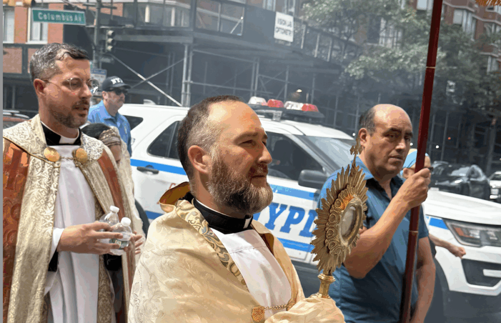 El padre George Sears (sosteniendo la custodia) lleva el Santísimo Sacramento durante la procesión eucarística del Upper West Side en Corpus Christi, el domingo 30 de junio de 2025.