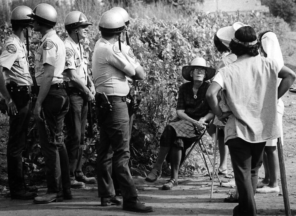 Police and farm workers flank Catholic Worker founder Dorothy Day, seated in a farm workers' picket line in Lamont, California, in 1973.