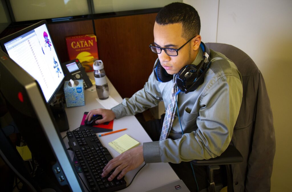 En esta foto de archivo, Nicholas Bautista, estudiante de último año en la escuela secundaria Cristo Rey de Nueva York, trabaja en su cubículo en la firma de valores Liquidnet, en el centro de Manhattan, en esta foto de archivo de abril de 2018.