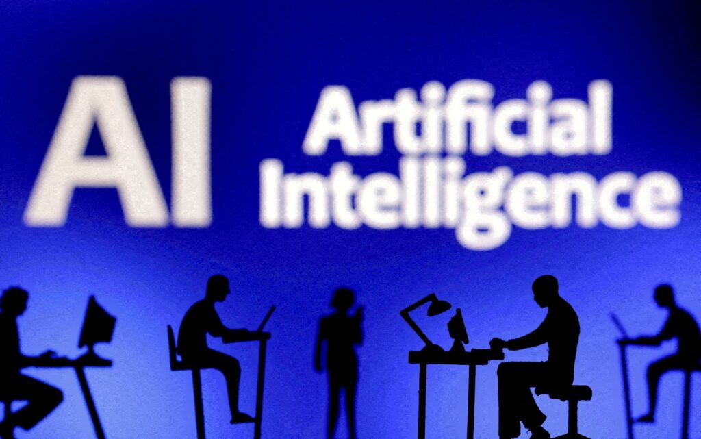 Figurines with computers and smartphones are seen in front of the words "AI Artificial Intelligence" on February 19, 2024, illustration.