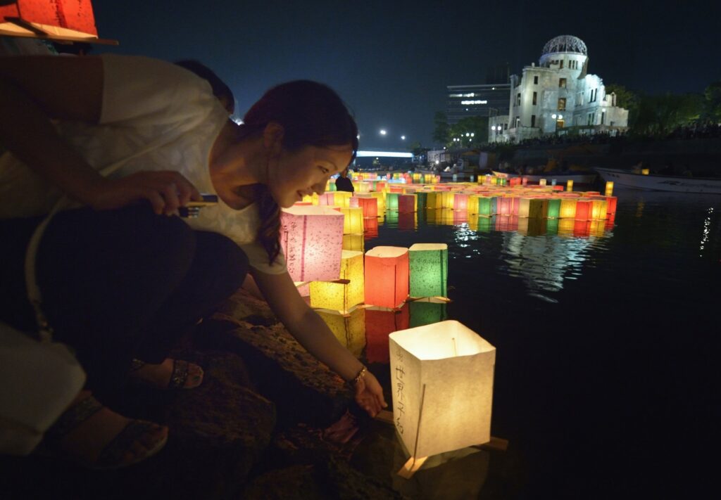 Una mujer coloca una vela flotante en el río el 6 de agosto de 2015 en Hiroshima, Japón, en conmemoración del 70.º aniversario del bombardeo atómico de la ciudad.