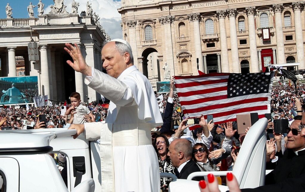 Se muestra una bandera estadounidense mientras el Papa León XIV, antes cardenal Robert Francis Prevost, ondea cuando llega para celebrar su Misa de inauguración en el Vaticano el 18 de mayo de 2025. Él es el primer pontífice estadounidense en la historia.
