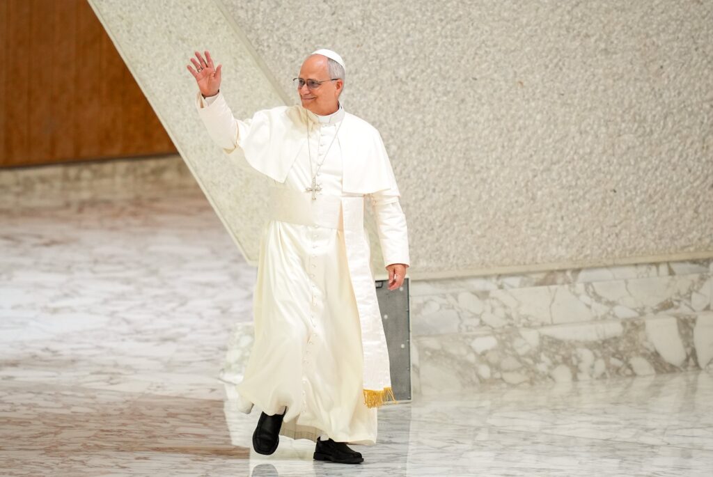 Pope Leo XIV greets visitors and pilgrims as he arrives in the Paul VI Audience Hall at the Vatican for his weekly general audience Aug. 20, 2025.