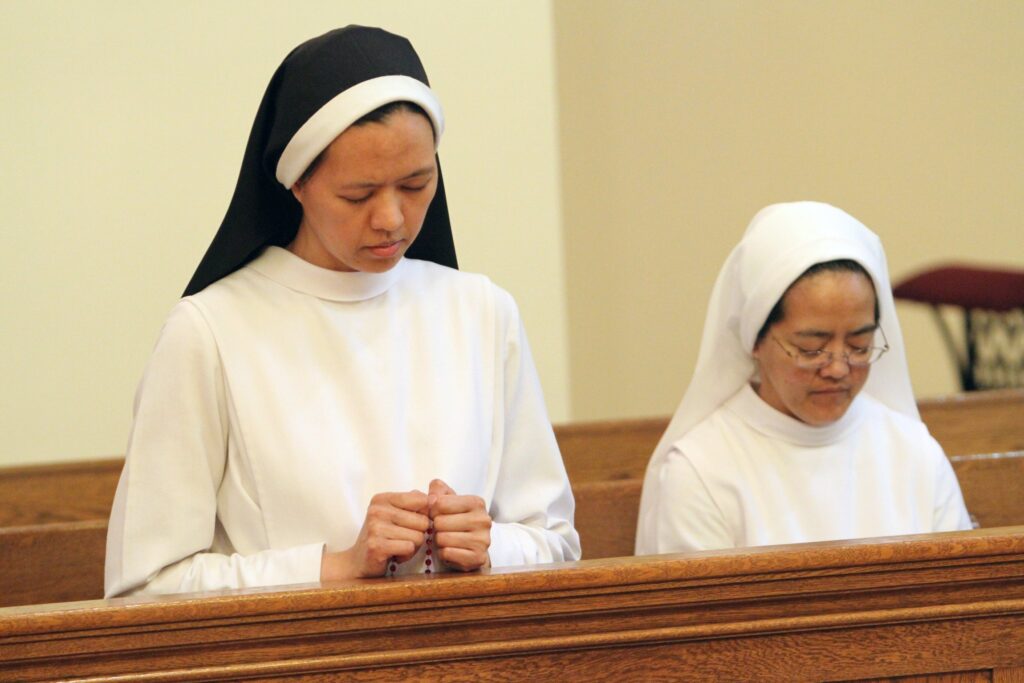 Dominican Sisters Carmela Marie, left, and Mary Michaela pray in the chapel at Rosary Hill Home in Hawthorne, in this file photo.