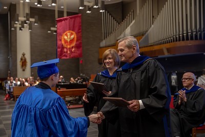 James L. Hayes, retiring president of The Epiphany School (Manhattan), shakes a student’s hand as he presents the eighth-grader his diploma during graduation in June 2025. Photo courtesy of The Epiphany School