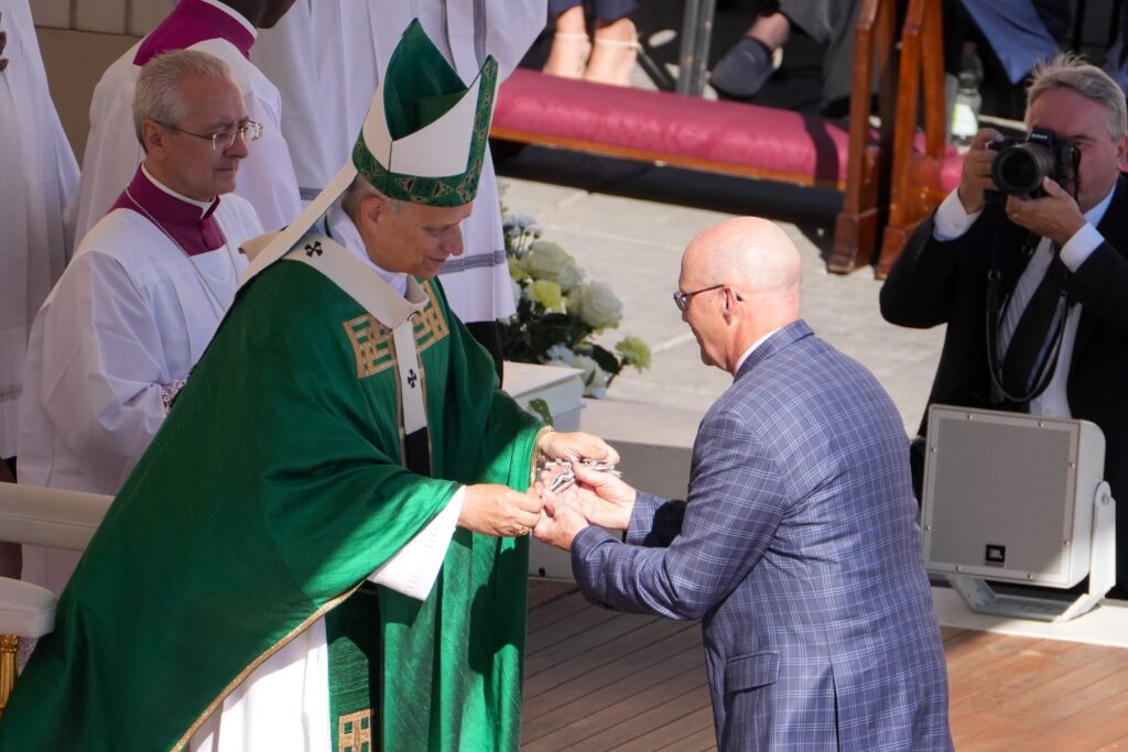 Pope Leo XIV gives a cross to David Spesia, executive director of the U.S. bishops' Secretariat of Evangelization and Catechesis, as he installs him in the ministry of catechist at the Jubilee of Catechists Mass in St. Peter’s Square at the Vatican on September 28, 2025.