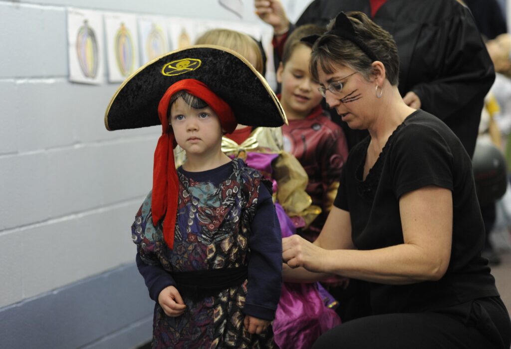 Four-year-old Quillan Yates gets a helping hand with his pirate costume from teacher Barbara Thomas October 30, 2009 during a Halloween party at St. Mary School in Canandaigua. Photo: CNS/Mike Crupi, Catholic Courier