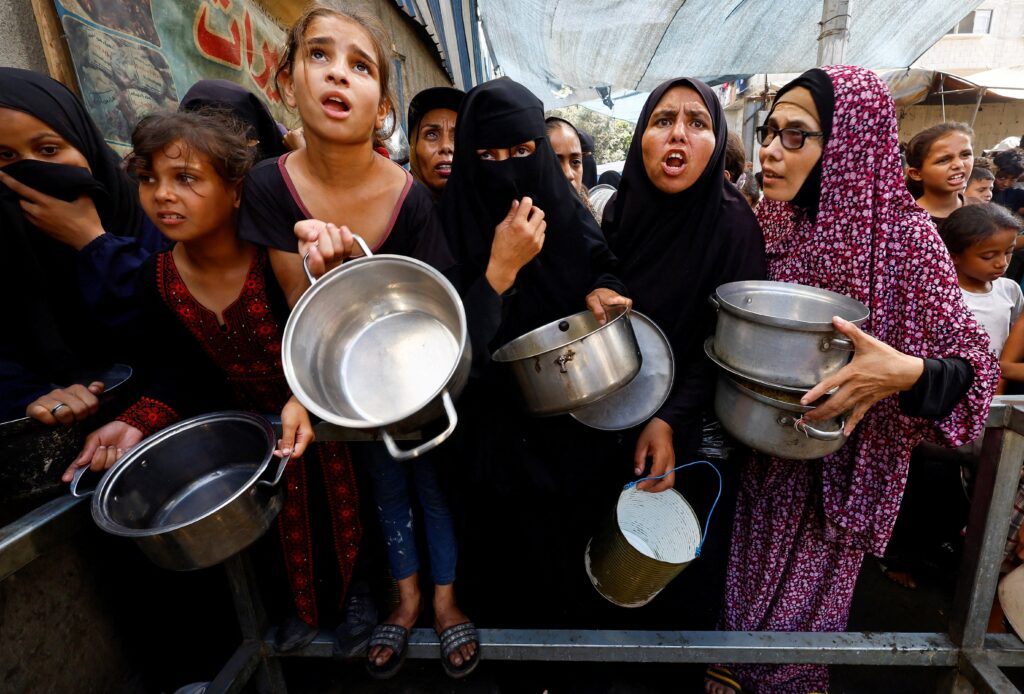 Palestinians gather to receive food from a charity kitchen, amid a hunger crisis, in Nuseirat, central Gaza Strip, on September 28, 2025.