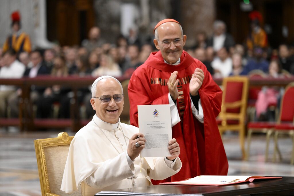 Pope Leo XIV smiles as he holds up his apostolic letter “Drawing New Maps of Hope," marking the 60th anniversary of the Vatican II declaration on Catholic education, which will be celebrated on October 28.