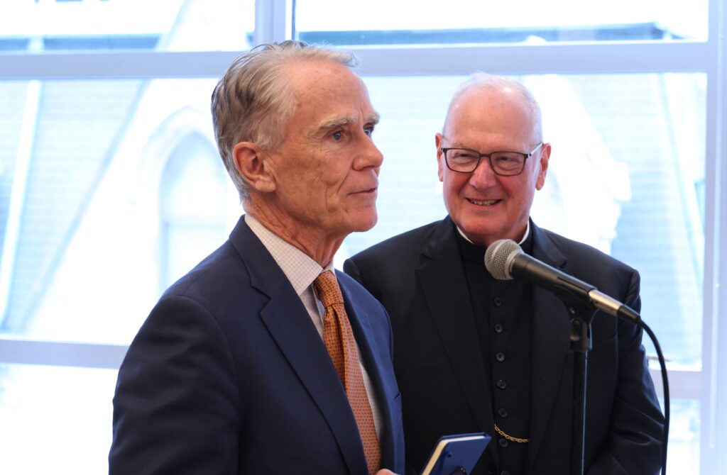 John Cahill, chancellor of the Archdiocese of New York, speaks to archdiocesan staff members at a celebration as Cardinal Timothy Dolan looks on, October 28, 2025.