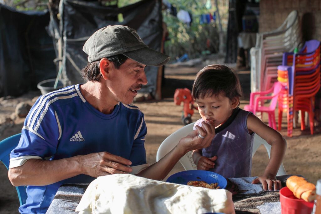 Farmer Santos Sorto feeds his son, Caleb, in La Caída, El Salvador. The family participates in a Catholic Relief Services program, which aims to mitigate the impact of COVID-19 pandemic and losses due to climate change. Photo: OSV News/Oscar Leiva, Silverlight, Catholic Relief Services