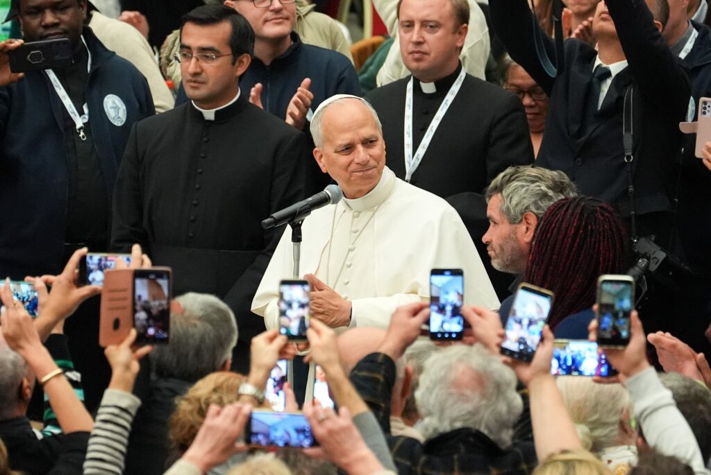 Pope Leo XIV speaks to attendees before having lunch with thousands of people assisted by church charities in the Paul VI Audience Hall at the Vatican on November 16, 2025.