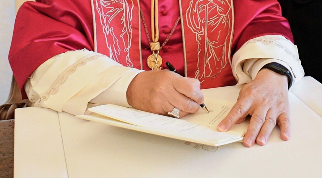 Pope Leo XIV signs a document in this file photo from October 4, 2025.