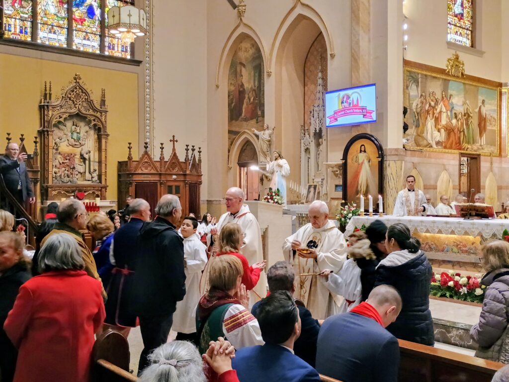El cardenal Timothy Dolan y el padre Marek Rudecki, párroco, administran la Sagrada Comunión durante el centenario Misa de aniversario de la estructura actual de la Iglesia de St. Casimir, Yonkers, sábado 22 de noviembre de 2025.