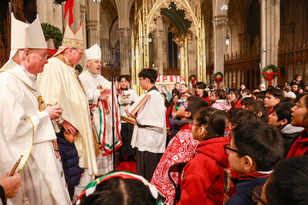 Archdiocese of New York Auxiliary Bishop Edmund J. Whalen (left), Cardinal Timothy Dolan (center left) and Auxiliary Bishop Joseph Espaillat (at microphone) offer a blessing hundreds of young pilgrims who participated in the Our Lady of Guadalupe procession and then Mass on the Our Lady’s feast day, December 12, 2025, at St. Patrick’s Cathedral.