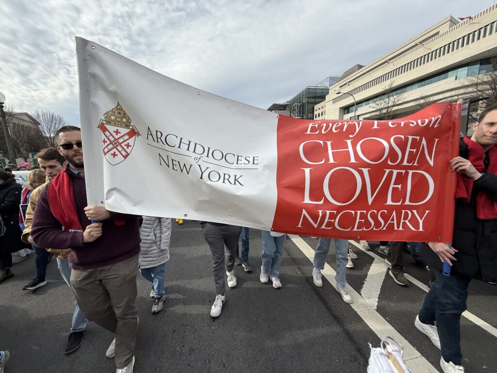 Marchers at the 2026 March for Life in Washington, D.C., hold a banner with the Archdiocese of New York heraldry that reads “Every Person Chosen Loved Necessary.”