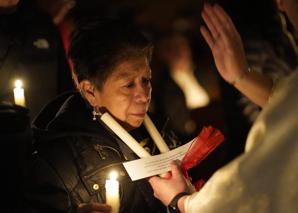 A woman has her throat blessed during a Spanish-language candlelit Mass on the eve of the feast of the Presentation of the Lord, also known as Candlemas, at St. Joseph Church on Staten Island on February 1, 2025.