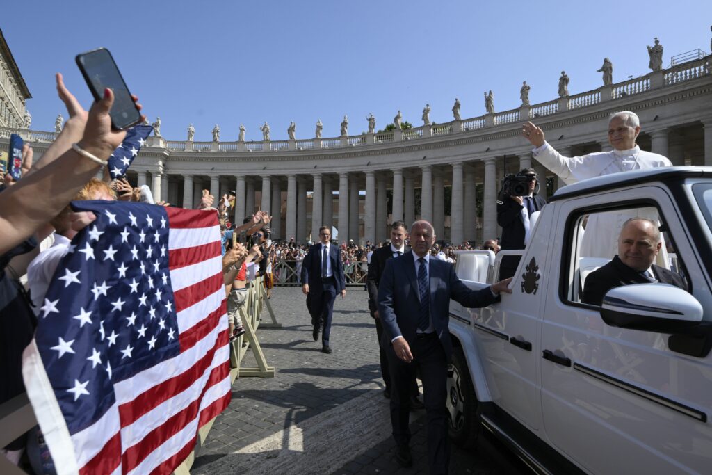 Pope Leo XIV waves to pilgrims holding a flag of the United States as he arrives in St. Peter's Square on the popemobile for his general audience at the Vatican on June 18, 2025.