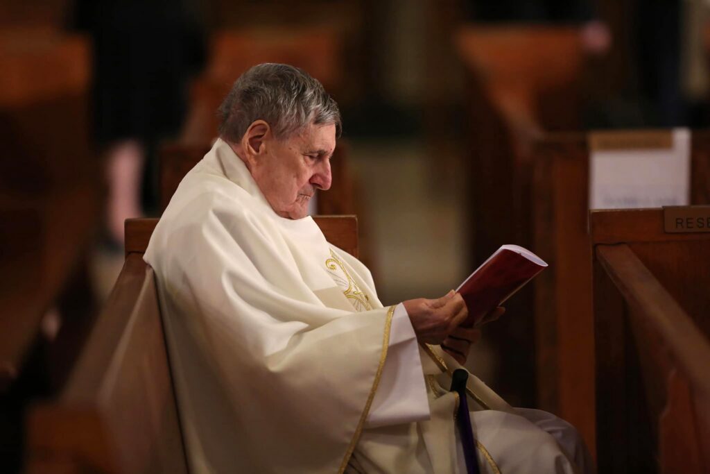 Monsignor James Turro, then 92, reads the program ahead of the January 6, 2017, installation Mass for Cardinal Joseph W. Tobin as the archbishop of Newark, New Jersey, at the Cathedral Basilica of the Sacred Heart in Newark.