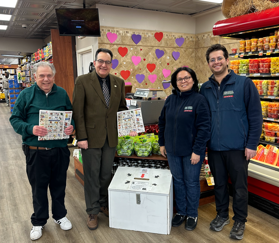Big Deal Supermarket owner and community philanthropist Miguel Garcia is represented by Managers Gretty Garcia (second from right) and Jesse Clemente (right) at the Lenten Fundraiser kickoff at Big Deal Supermarket. Joining them are Anthony J. Merolla Holy Name Society President Joseph Madia (second from left) and President Emeritus Martin Dolgow (left). The large white box in the center serves to collect receipts from customers for the fundraiser.