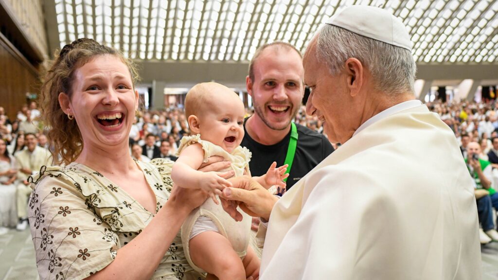 El papa León XIV saluda a un bebé y a su familia al término de su audiencia general semanal en la Sala de Audiencias Pablo VI del Vaticano, el 27 de agosto de 2025. (Foto CNS/Vatican Media)