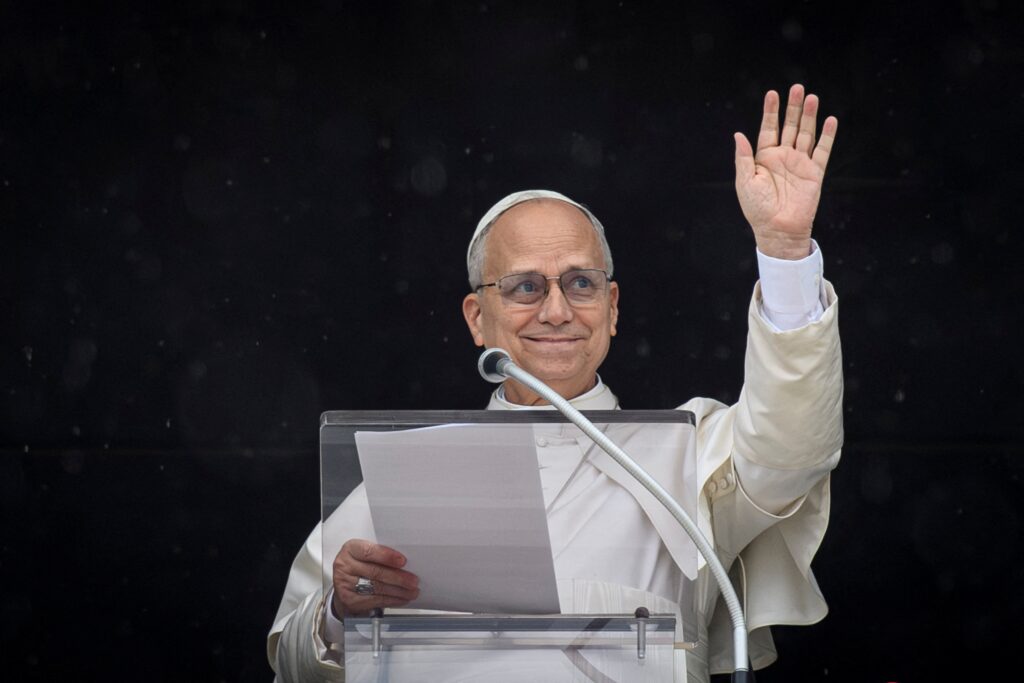 Pope Leo XIV waves as he leads the Angelus prayer from a window of the Apostolic Palace, at the Vatican on March 22, 2026.