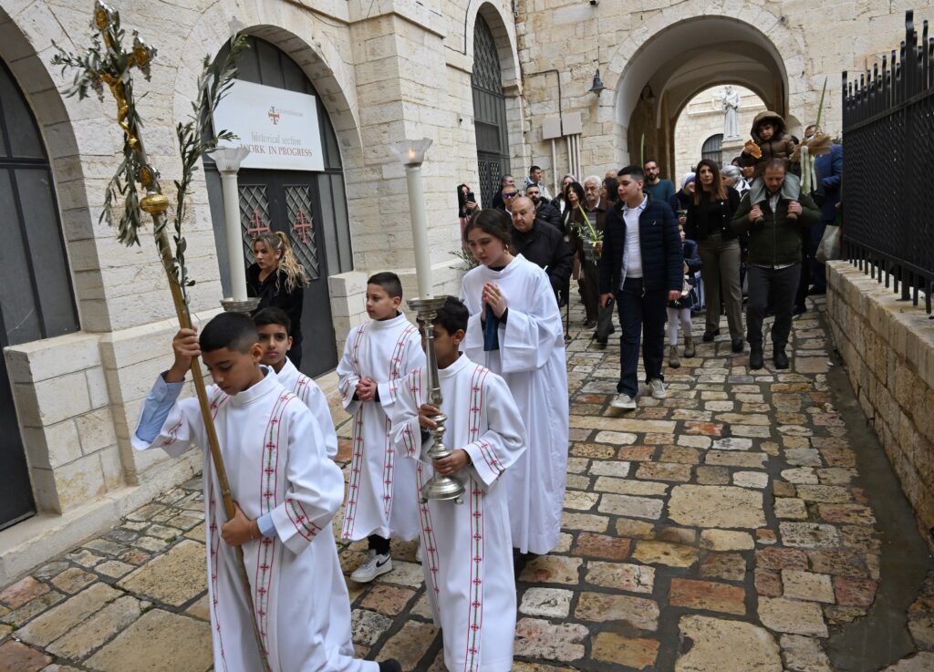 Palestinian Catholics process during the blessing of the olive branches on Palm Sunday outside St. Savior Monastery in Jerusalem's Old City, March 29, 2026. The traditional Palm Sunday procession was cancelled because of the U.S.-Israeli war with Iran by the Israeli Home Front Command. Photo: OSV News photo/Debbie Hill